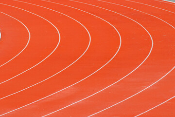 Red running track in sports fields and green grass