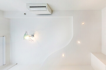 Stretch ceiling white and complex shape with halogen spots lamps and drywall construction in empty...