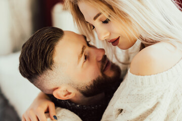A close up portrait of two lovers. Bearded man looking at his woman. Caring man showing love to attractive his woman, enjoying tender moment.