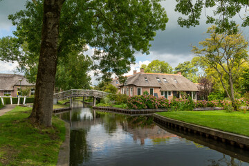 Fototapeta na wymiar House with hydrangeas in the garden at the canal in Giethoorn