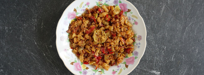 Salted shredded fish or abon is a traditional Indonesian food made from mashed salted fish, it tastes salty, spicy and delicious. Served on a white plate and stone pad.