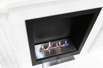 Gas fireplace on a white wall background. View from above. Close-up.