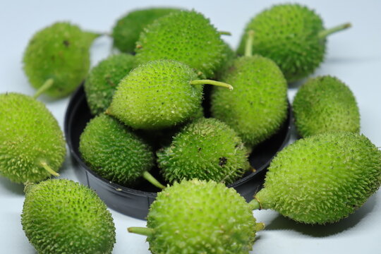 Fresh green colorful spiny gourd or teasel gourd vegetables on white background
