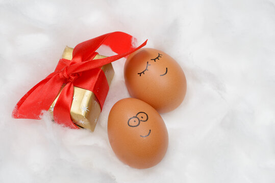Funny lovely eggs in snow with gift box
