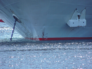 Ship Bow from dead ahead with bow wave. Ship is white hull and the red waterline.