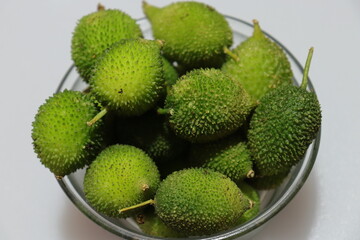 Fresh green colorful spiny gourd or teasel gourd vegetables on white background