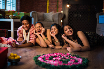 Indian Kids celebrating Diwali / Deepawali, Bhai Dooj or Rakhi / Raksha Bandhan with flower...