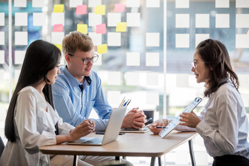 Successful team A group of young Asian business people plan and brainstorming together in the office.