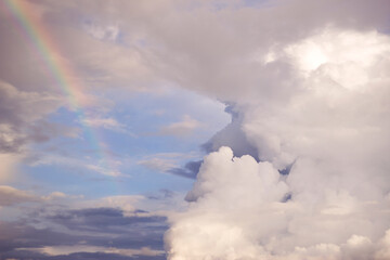 Fototapeta na wymiar power and tenderness of kissing clouds, with little magic of rainbow