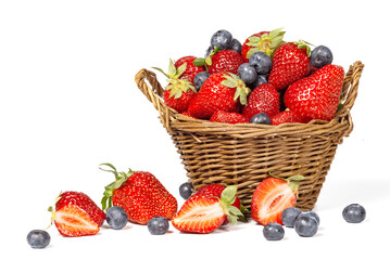 Strawberries with blueberries and basket isolated on a white background.