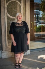 Plus size woman, American or European appearance walks in the city enjoying life. A young lady with excess weight, stylishly dressed in the center of the city. Natural beauty