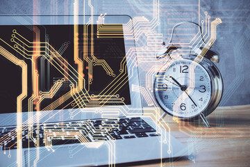 Computer on desktop in office with technology theme hologram. Double exposure. Tech concept.