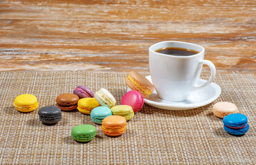 a white cup of coffee and macaroons