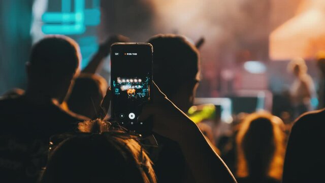 Female Hand with Smartphone Making Live Broadcast in Social Networks at Concert. Slow Motion