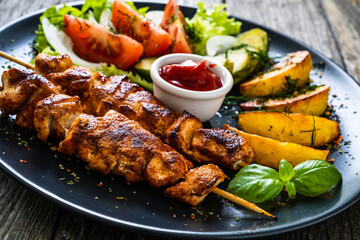 Fried souvlaki, potatoes with fresh vegetables 