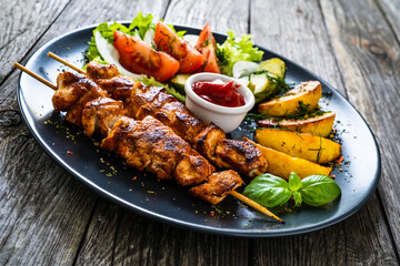 Fried souvlaki, potatoes with fresh vegetables 