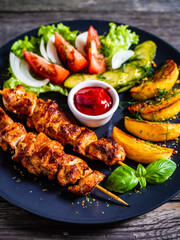 Fried souvlaki, potatoes with fresh vegetables 