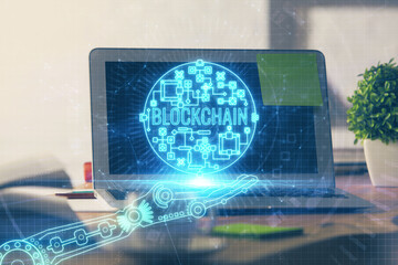 Double exposure of blockchain theme hologram and table with computer background. Concept of bitcoin crypto currency.