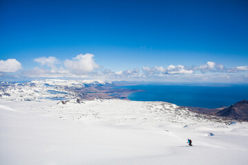 A skier skiing down an Icelandic Volcano with a glacier, southwest Iceland