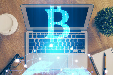 Multi exposure of blockchain theme hologram and table with computer background. Concept of bitcoin...