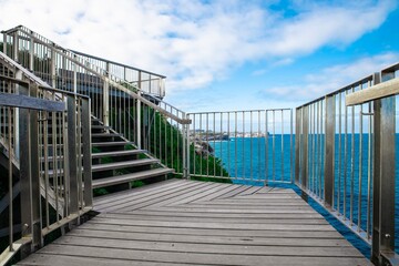 Bronte Beach walkway on rock cliff with views of Bondi Beach houses on the cliff Sydney Australia