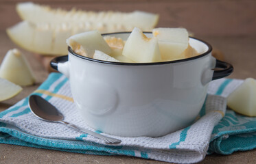 A delicious breakfast of slices of ripe and juice melon in a white bowl.