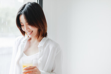 Asian women drink by the French windows