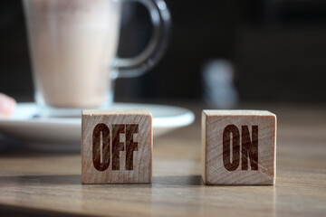 Two wooden blocks with inscription OFF and ON and cup of cacao. Selective focus. Business and...
