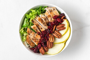 healthy chicken lunch bowl salad. Chicken breast, pear, pecan nuts and dried berries autumn salad....