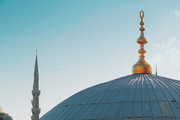 Fototapeta na wymiar Istanbul Turkey, high minaret of a mosque and a spire with a Crescent moon on top of the dome,