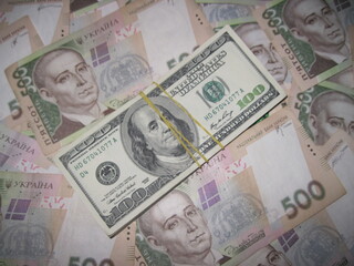 Financial background with a lot of paper banknotes of USA 100 dollars and Ukraine 500 hryvnia is great for editorial publication about money exchange. 