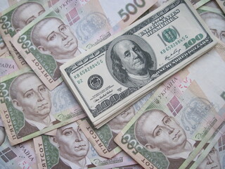 Financial background with a lot of paper banknotes of USA 100 dollars and Ukraine 500 hryvnia is great for editorial publication about money exchange. 