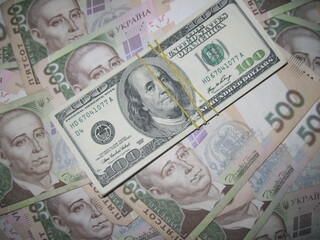 Financial background with a lot of paper banknotes of USA 100 dollars and Ukraine 500 hryvnia is great for editorial publication about money exchange. 