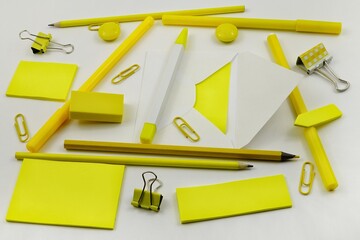 Various stationery in yellow are laid out on a white table