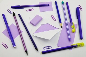 Stationary in violet colors lie on a white table