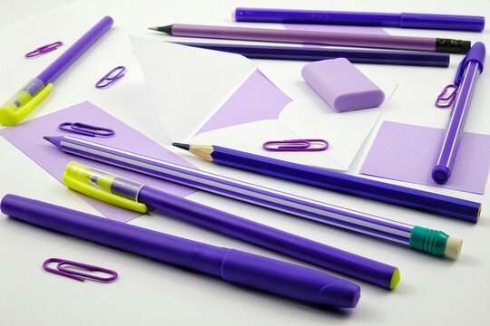 Stationary in violet colors lie on a white table