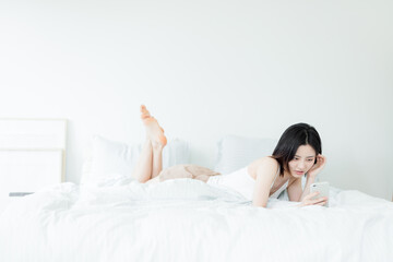 Obraz na płótnie Canvas Asian woman using mobile phone indoors