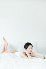 Obraz premium Asian woman using mobile phone indoors