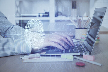Fingerprint hologram with businessman working on computer on background. Security concept. Double...