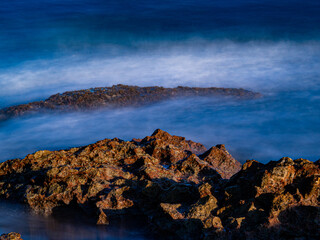 sea water hitting the shore stones with silk effect