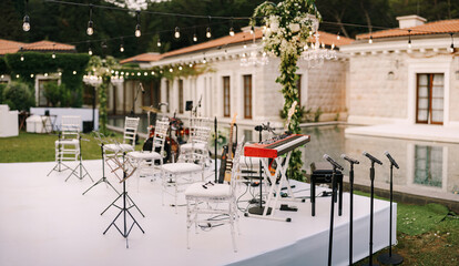 Fototapeta na wymiar The scene of wedding musicians in the open air, against the backdrop of a pool and an old villa in Montenegro.