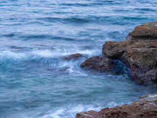 sea water hitting the shore stones with silk effect