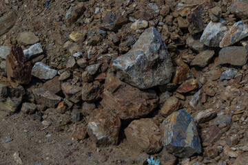 rough textured chipped stones among a dirty brown pile of earth