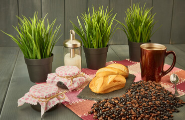 Breakfast with a cup of coffee and milk bread, honey and jam, sugar and a sample of natural and roasted coffee