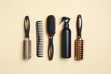 Flat lay composition with modern hair comb and brushes on beige background
