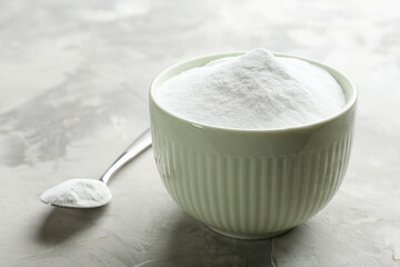 Baking soda in bowl on grey table