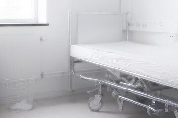 creative image of empty hospital bed with soft light from a window.