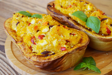 Stuffed butternut squash with quinoa, sweet paprika,carrots and cheese on wood background. Healthy eating concept. Top view