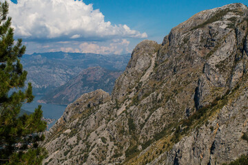 Bay of Kotor from the heights. View from Mount Lovcen to the bay. View down from the observation platform on the mountain Lovcen. Mountains and bay in Montenegro. The liner near the old town of Kotor.