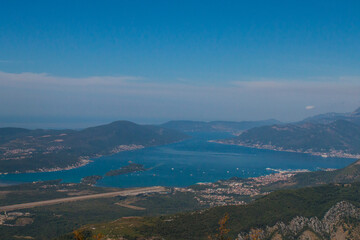 Obraz premium Bay of Kotor from the heights. View from Mount Lovcen to the bay. View down from the observation platform on the mountain Lovcen. Mountains and bay in Montenegro. The liner near the old town of Kotor.